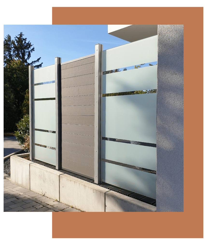 Modern privacy fence with frosted glass and metal accents along a backyard property