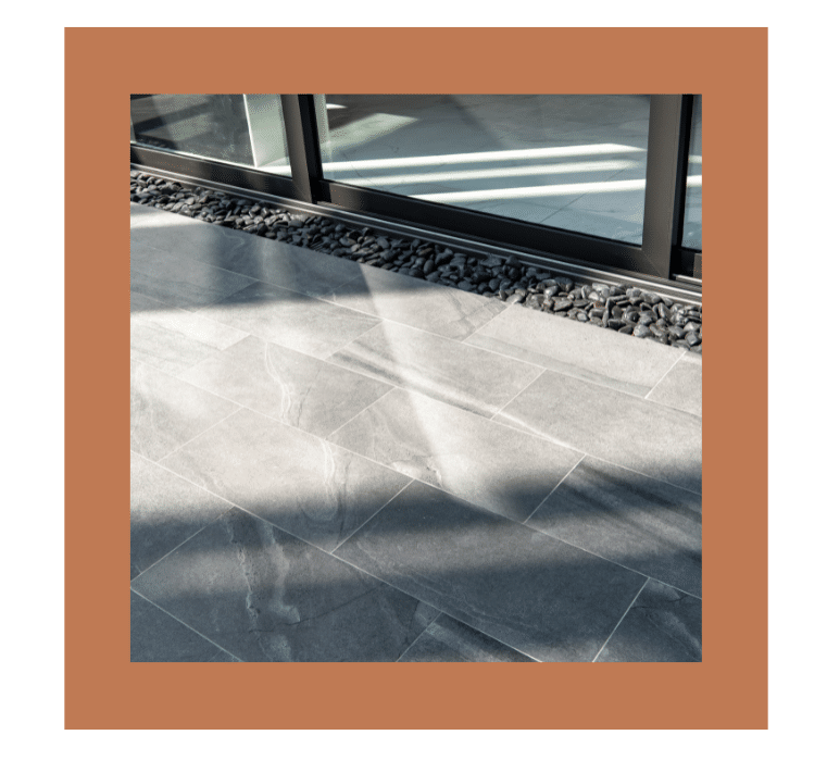 Sleek gray tiles paired with TREX composite decking in a contemporary low-maintenance patio