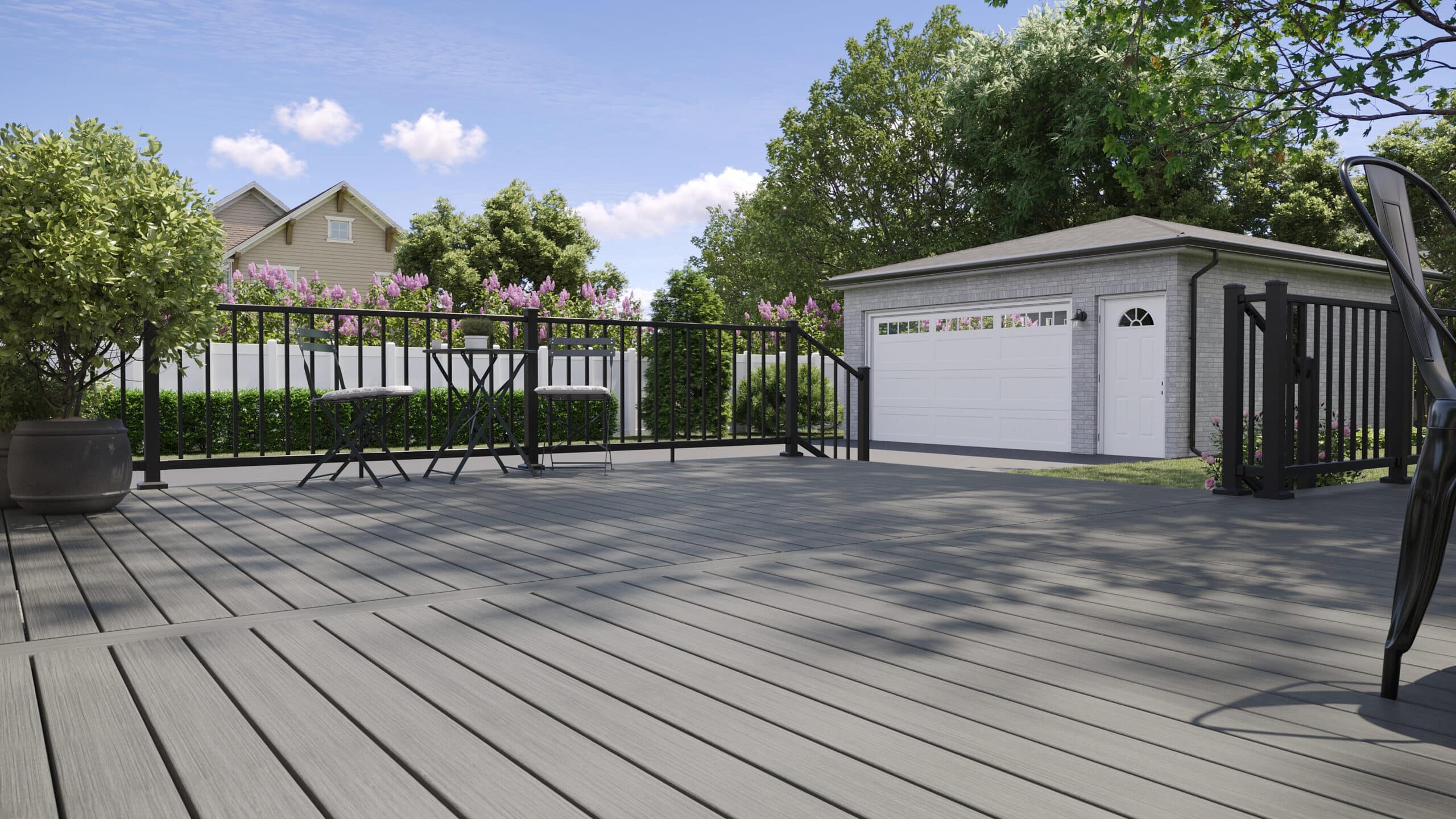 TREX composite decking in gray finish with black aluminum railings in a landscaped backyard