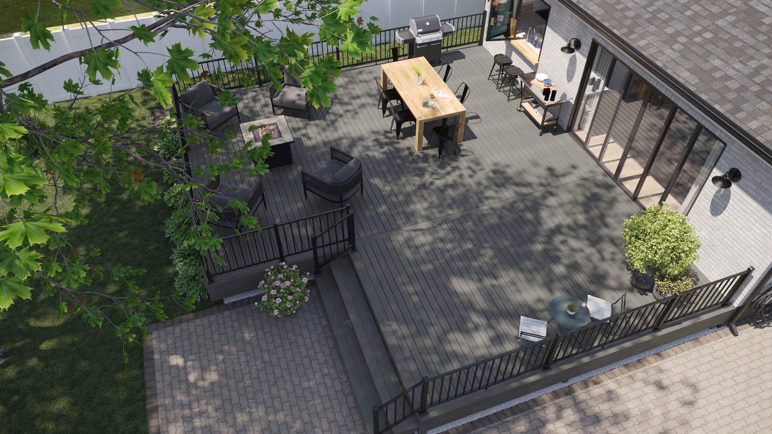 Aerial view of a large TREX composite decking patio with dining table, seating area, and greenery